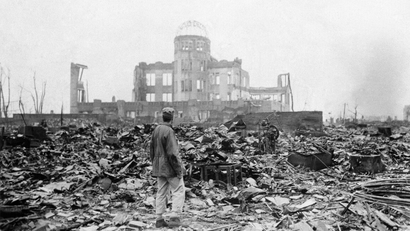 FILE - In this Sept. 8, 1945 file photo, an allied correspondent stands in the rubble in front of the shell of a building that once was a movie theater in Hiroshima, Japan, a month after the first atomic bomb ever used in warfare was dropped by the U.S. on Aug. 6, 1945. A contentious debate over nuclear power in Japan is also bringing another question out of the shadows: Should Japan keep open the possibility of making nuclear weapons _ even if only as an option? It may seem surprising in the only country ever devastated by atomic bombs, particularly as it marks the 67th anniversary of the bombings of Hiroshima on Aug. 6, 2012, and Nagasaki three days later. The Japanese government officially renounces nuclear weapons, and the vast majority of citizens oppose them. The damaged building standing in the background is the Hiroshima Prefectural Industrial Promotion Hall, currently preserved as the Atomic Bomb Dome.