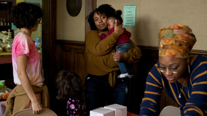 Siwatu-Salama Ra, 27, holds her 10-month-old son Zakai during her daughter Zala's 4th birthday party at the Cass Commons, the site of Siwatu's work, in Detroit, Mich., on March 24, 2019.
