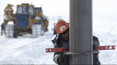 A worker installs a pipe support for the oil transportation to Vankor at the Rosneft company owned Suzunskoye oil field, north from the Russian Siberian city of Krasnoyarsk.