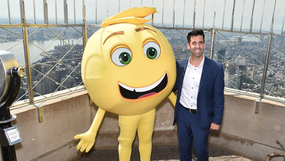 Jeremy Burge on an observation deck of the Empire State Building with a person dressed as an emoji face.