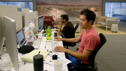 Two colleagues working side by side in a startup office.