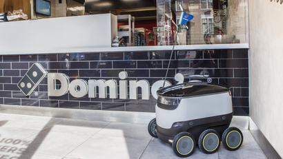 A Starship robot in front of a Domino's counter