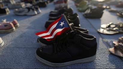 A Puerto Rican flag is seen on a pair of shoes as hundreds of pairs of shoes displayed at the Capitol to pay tribute to Hurricane Maria's victims