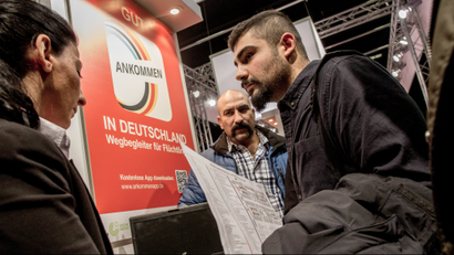 Two men from Iran talk to a staff member at the booth of the German Federal Labour Office at the job fair for refugees in Berlin, Germany, 29 February 2016. Several thousand of refugees came to get information on job and training offers of about 200 companies and educational institutions.