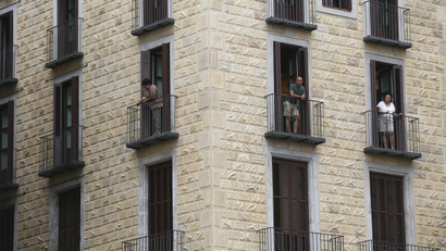 People look at the view from an apartment at Sant Jaume square at Gothic quarter in Barcelona, Spain, August 18, 2015. Barcelona's new mayor is picking a fight with home rental websites as she tries to crack down on uncontrolled tourism that she fears could drive out poor residents and spoil the Catalan capital's charm. Picture taken on August 18, 2015.