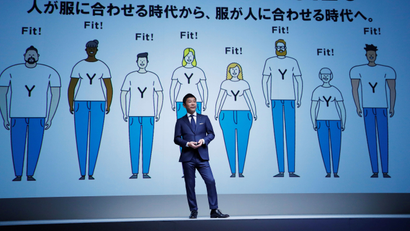 Yusaku Maezawa, the chief executive of Zozo, which operates Japan's popular fashion shopping site Zozotown and is officially called Start Today Co, speaks in front of a projection about Zozosuit at an event launching the debut of its formal apparel items, in Tokyo, Japan, July 3, 2018. Picture taken July 3, 2018. REUTERS/Kim Kyung-Hoon - RC1578C27420