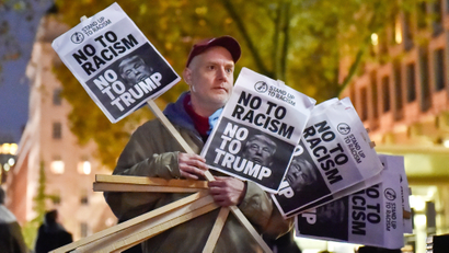 A man holds placards at an anti-racism protest against U.S. President-elect Donald Trump outside of the U.S Embassy in London