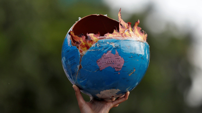 A participant holds a replica depicting globe on fire during a "Fridays for Future" march calling for urgent measures to combat climate change, in Mumbai