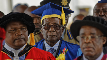 Zimbabwe's President Robert Mugabe, center, arrives to preside over a student graduation ceremony at Zimbabwe Open University on the outskirts of the capital, Harare, on Nov. 17, 2017.
