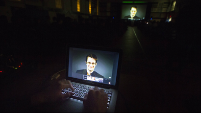 A student works on a computer that is projecting former U.S. National Security Agency contractor Edward Snowden as he appears live via video.