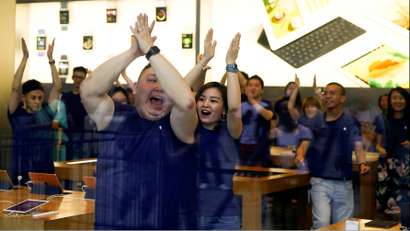 Staff members perform a dance routine before opening an Apple store to customers who line up to purchase the new iPhone 7 in Beijing, China, September 16, 2016.