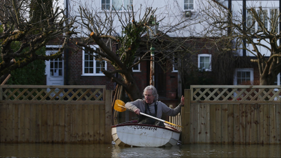 Nigel Gray leaves his home in a rowing boat after the river Thames flooded the village of Wraysbury, southern England February 10, 2014. REUTERS/Eddie Keogh