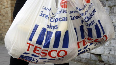 Tesco shopping bags are carried in London,.