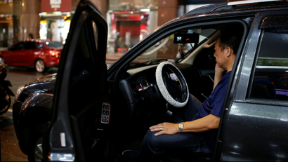 A man uses his mobile phone as he sits in a luxury car in Taipei, Taiwan