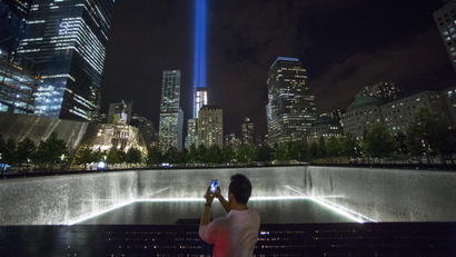 A man takes a photo at the 9/11 Memorial and Museum near the Tribute in Light in Lower Manhattan, New York.