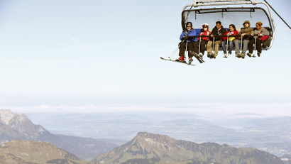 Skiers and tourists sit in a chair lift at the Mount Titlis skiing area