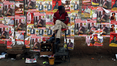 A man looks at campaign posters as he waits to cast his ballot, during the Jubilee Party primary elections, outside a polling centre in Nairobi, Kenya April 26, 2017.