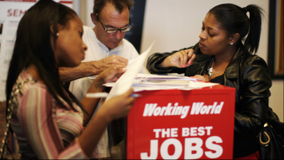 People fill out job application forms at a job fair in Los Angeles, California
