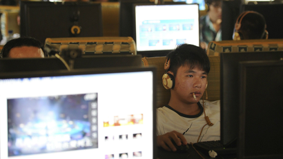 A man smokes as he uses a computer at an internet cafe in Hefei, Anhui province, September 15, 2011.