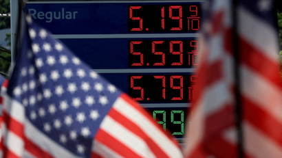 Gasoline prices are displayed at an Exxon gas station behind American flag in Edgewater, New Jersey.