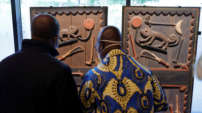 Visitors look at doors of King Glele's Palace (1880-1889) displayed during the exhibition "Restitution of 26 works from the royal treasury in Abomey" at the Quai Branly museum before a ceremony to mark the return of 26 artworks of the Kingdom of Dahomey to Benin, in Paris.