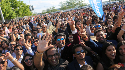 Audience members wave while queuing before the International Indian Film Academy Awards show at MetLife Stadium in East Rutherford