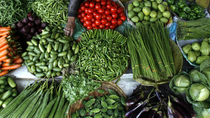 Vendor arranges vegetables at wholesale market in Siliguri
