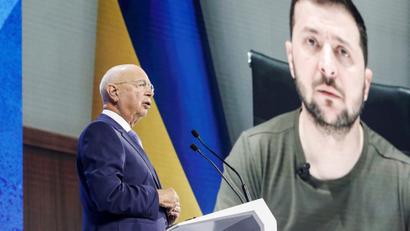 Klaus Schwab addresses the delegates at Davos with Ukraine president Volodymyr Zelenskyy displayed on a screen in the background during the opening ceremony of the World Economic Forum (WEF) in Davos, Switzerland.