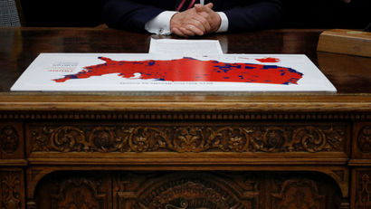 US president Donald Trump looks over a 2016 US presidential election results map.
