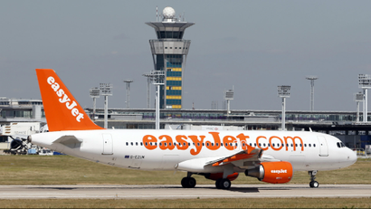 An Airbus A320 EasyJet passenger plane passes by the air traffic control tower as it prepares for take off at Orly Airport, near Paris.