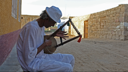 A man plays music on a traditional musical instrument in the Nubian village of Adindan near Aswan, south of Egypt, September 30, 2015. For half a century, Egypt's Nubians have patiently lobbied the government in Cairo for a return to their homelands on the banks of the Nile, desperate to reclaim territory their ancestors first cultivated 3,000 years ago. Yet all their efforts to gain political influence have brought next to nothing. In Egypt's incoming parliament, which will be finalised after a second round of voting on Sunday, the Nubians will hold just one of 568 elected seats. Picture taken September 30, 2015.
