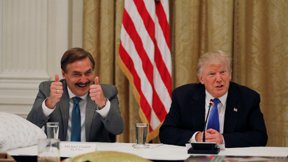 MyPillow CEO giving two thumbs up as he sits beside Trump at a roundtable meeting
