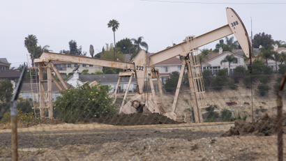 A general view shows two beige oil wells in Los Angeles