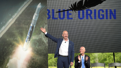 Amazon CEO Jeff Bezos, left, unveils the new Blue Origin rocket, as Florida Gov. Rick Scott, right, applauds during a news conference at the Cape Canaveral Air Force Station in Cape Canaveral, Fla., Tuesday, Sept. 15, 2015. Bezos announced a $200 million investment to build the rockets and capsules in the state and launch them using the historic Launch Complex 36.
