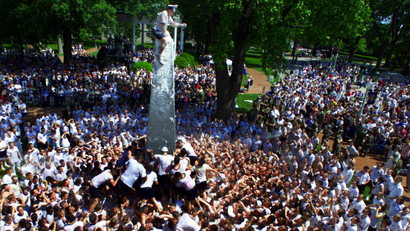 Daniel Shea, a 20-year-old U.S. Naval Academy midshipman from Lake Grove, N.Y., sits atop the 21-foot-tall, greased Herndon Monument at the Academy in Annapolis Monday, May 19, 2003, as he struggles to free a plebe hat and replace it with an upperclassman's hat. The Naval Academy's class of 2006 completed the right of passage in pretty fair time. It took the freshmen, or plebes, as they are called at the academy, one hour and 19 minutes to hoist Shea up the greased granite obelisk and retrieve a hat glued to the top. That was the fastest time since 1988, when the plebes accomplished the feat in just 43 minutes.