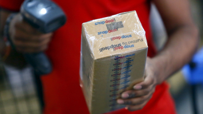 A worker of Indian e-commerce company Snapdeal.com scans barcode on a box after it was packed at the company's warehouse in New Delhi