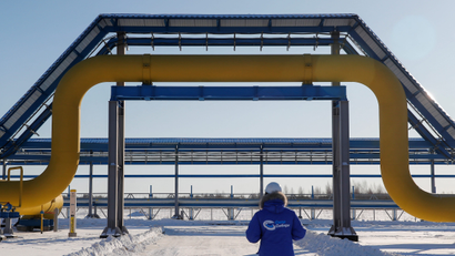 An employee in branded jacket walks past a part of Gazprom's Power Of Siberia gas pipeline at the Atamanskaya compressor station outside the far eastern town of Svobodny.