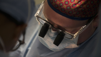 an image of a surgeon with microscope goggles on