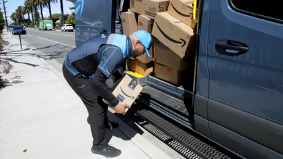 Joseph Alvarado picks up a package while making deliveries for Amazon during the outbreak of the coronavirus disease