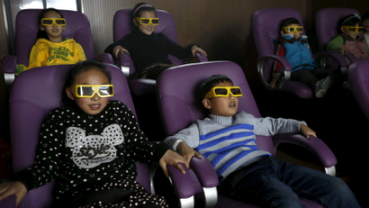 Children watch a 3D war movie at a community theatre in Hefei, Anhui province, March 29, 2015.