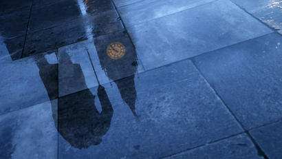 A rainy London street reflects Big Ben.