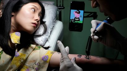 A woman gets a Peppa Pig tattoo at Samurai Tattoo studio in Shanghai, China May 3, 2018. Picture taken May 3, 2018. REUTERS/Aly Song - RC1326350E00