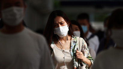Commuters wearing masks leave a train station during the pandemic.