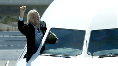 Richard Branson waves from the cockpit of a plane