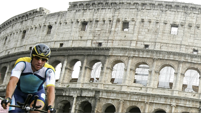 Lance Armstrong biking in front of the Colloseum.