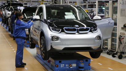 A worker makes final checks at the serial production BMW i3 electric car in the BMW factory in Leipzig