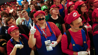 Cosplayers dressed as character "Mario" celebrate the 30th anniversary of "Super Mario Bros." video games developed by Nintendo during the Gamescom 2015 fair in Cologne
