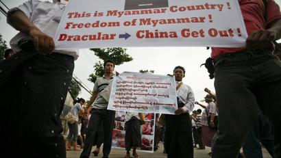 Protesters hold posters during a peaceful protest in support of Buddhist monks injured during a riot and against the Latbadaung Mountain Copper Mine project, in Yangon December 2, 2012.