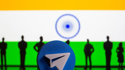 A 3D-printed Telegram app logo and small toy figurines are seen in front of India flag in this illustration