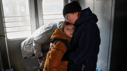 A parent and child embrace each other in an evacuation train from Kyiv to Lviv, at Kyiv central train station, amid Russia's invasion of Ukraine, in Kyiv,